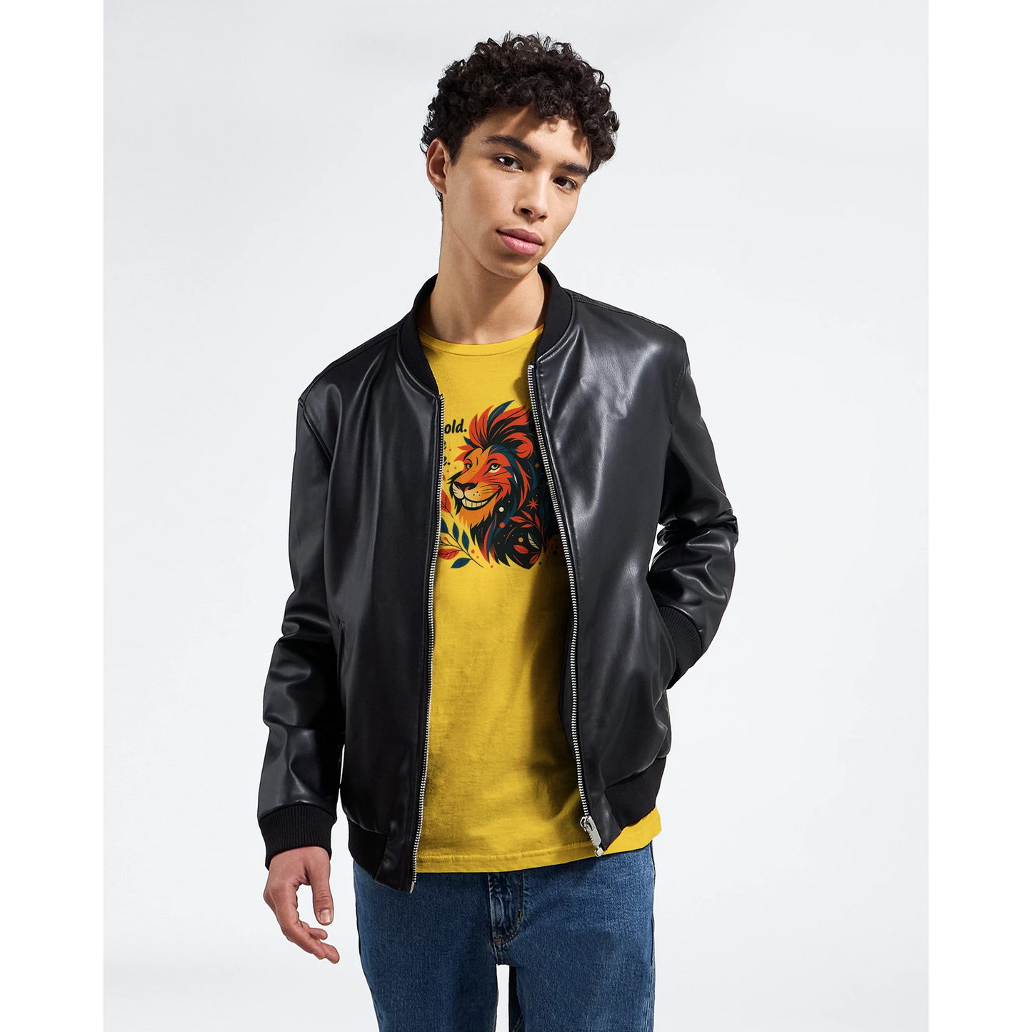 Male model wearing a yellow T-shirt with a lion illustration and slogan “Be Bold Stay Strong,” styled with a black jacket.