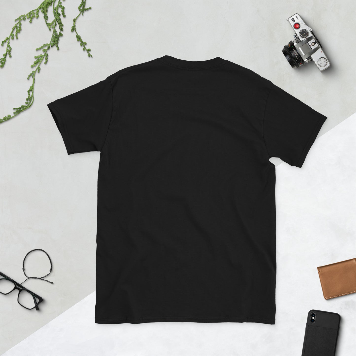 Black unisex T-shirt (flat lay) — front print: stylized face with white hair and neon sunglasses, text La sonrisa es tu / A smile is your logo. Lady Gaga.