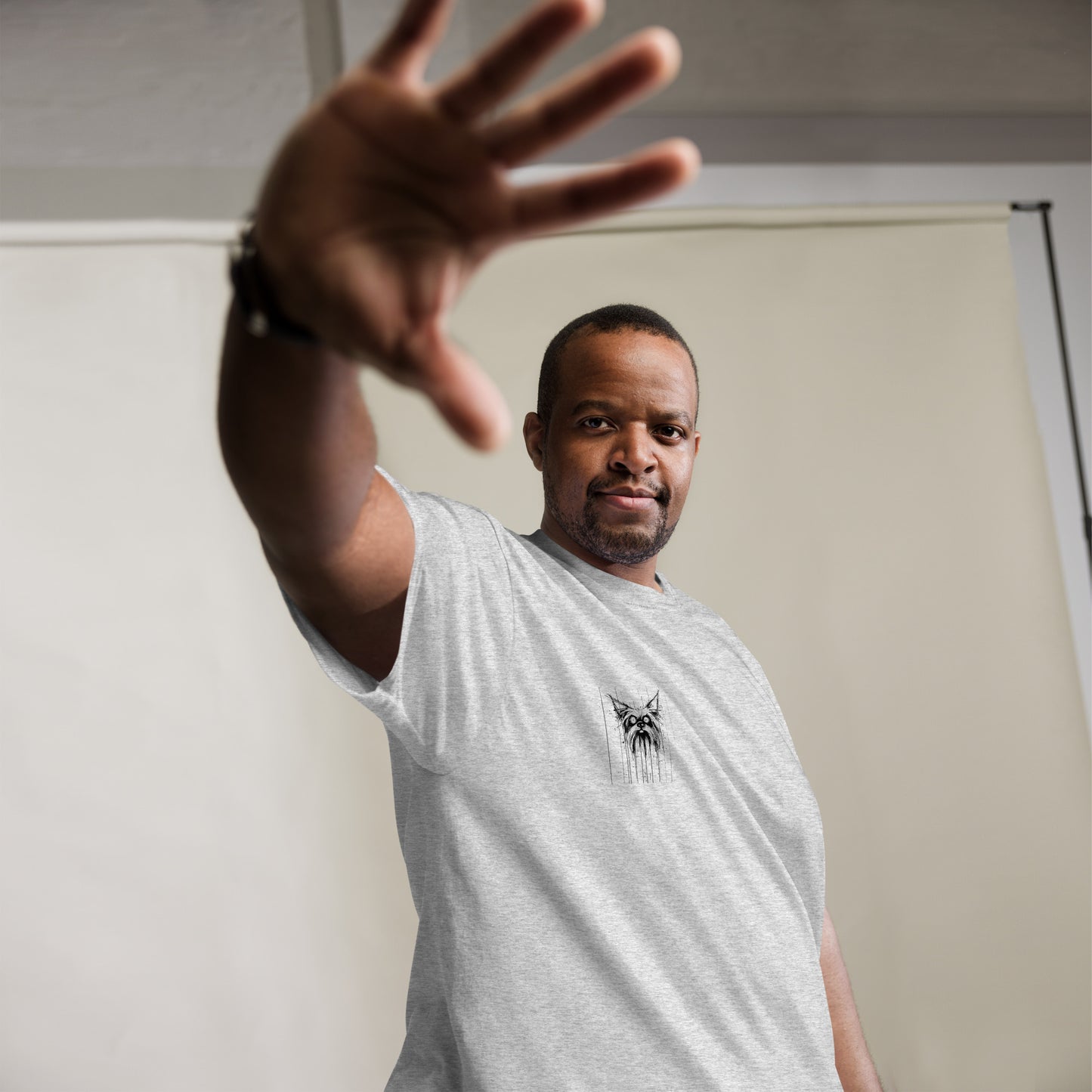 Male model raising hand playfully, wearing striped grey T-shirt with Yorkshire Terrier "Scared" artwork
