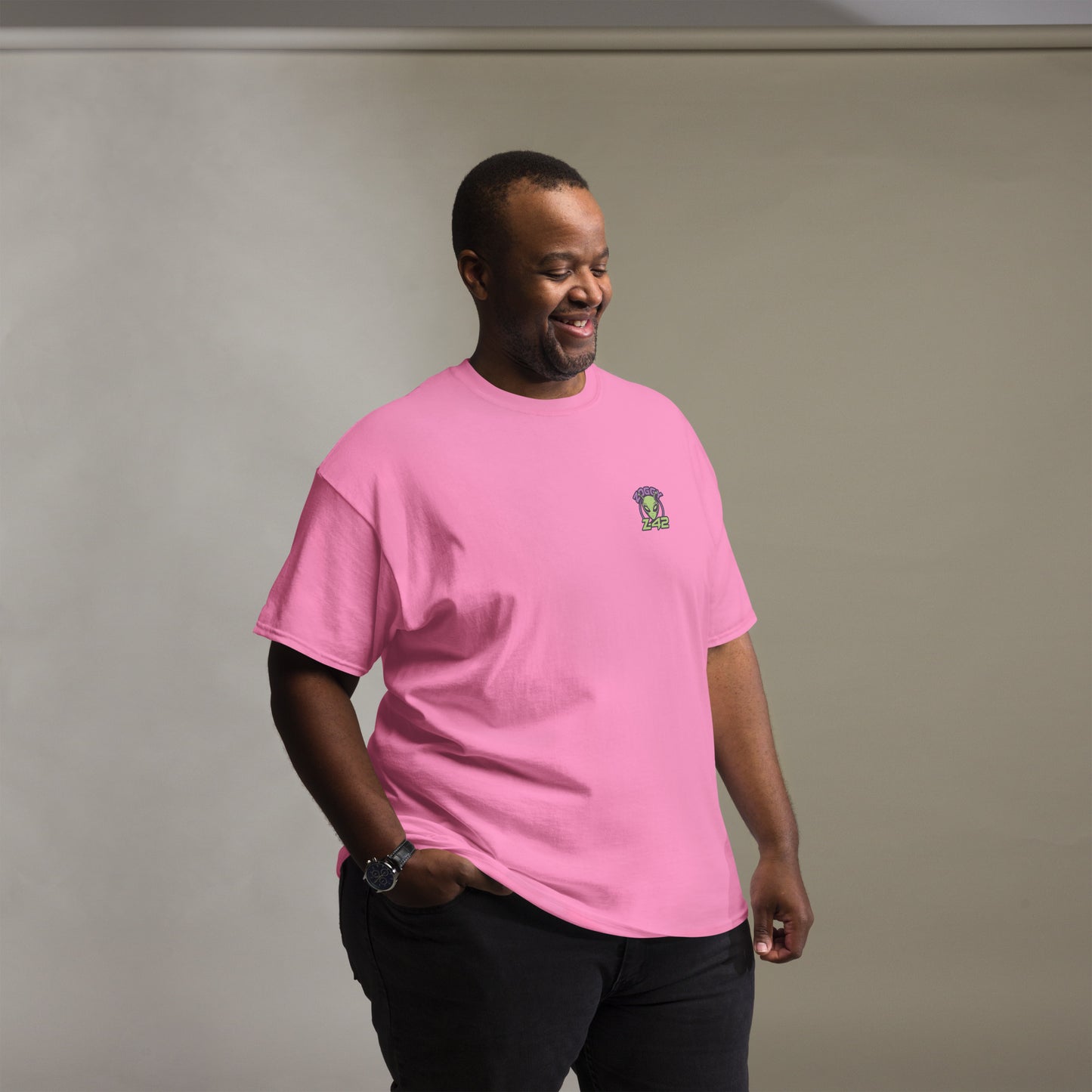Male model wearing pink T-shirt — front left chest small alien head graphic