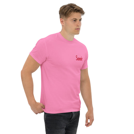 Male model wearing a pink T-shirt with Sonrie text and a colorful abstract side print