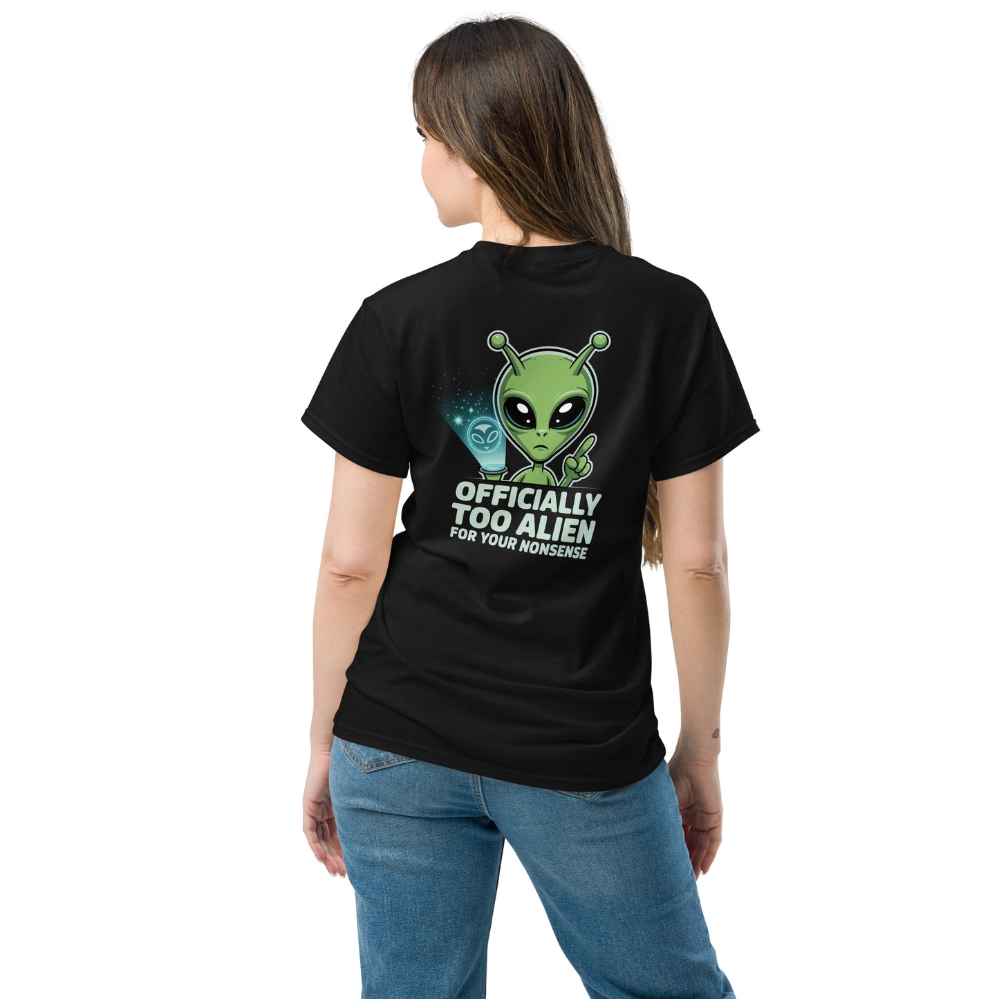 Female model wearing black T-shirt — back print: green alien with text OFFICIALLY TOO ALIEN FOR YOU HUMANS