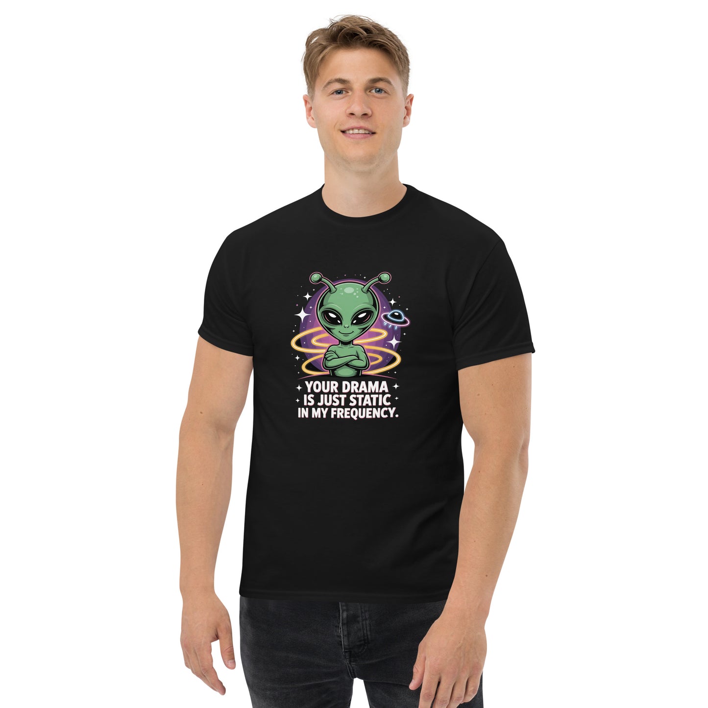 Male model wearing black T-shirt — front print: green alien with colorful background and text YOUR DRAMA IS NOT SPEAKING MY FREQUENCY
