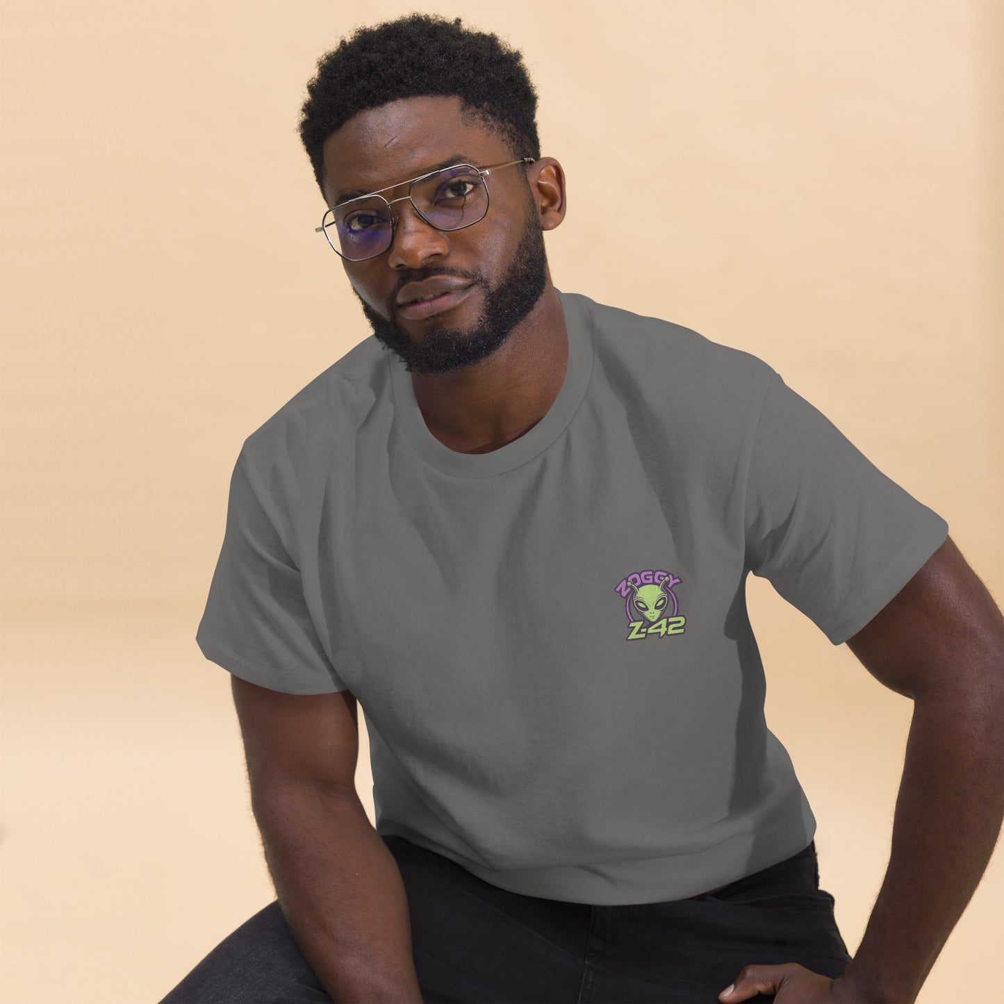 Male model wearing white T-shirt — front left chest small alien head graphic