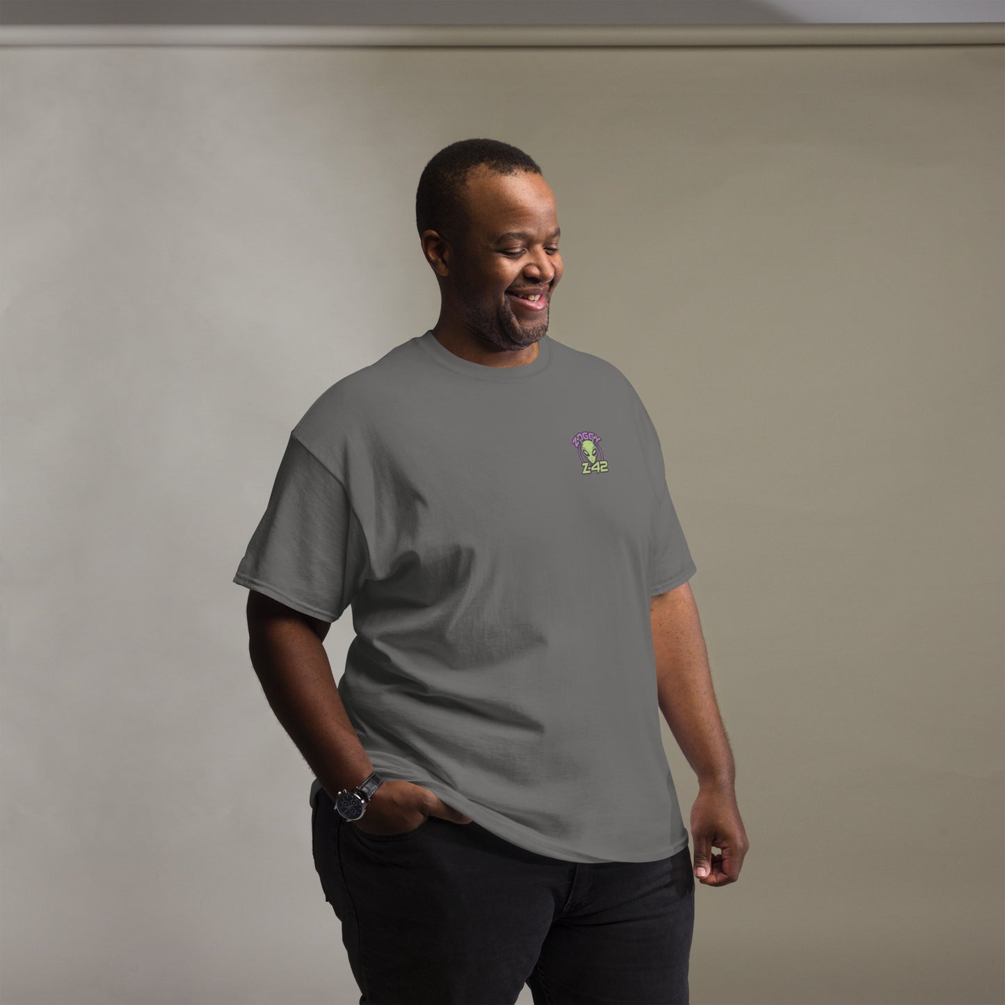 Male model wearing grey T-shirt — front left chest small alien head graphic