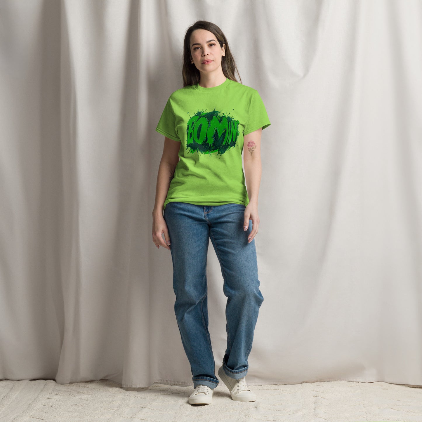 Woman in neon green BOOMIN statement tee with bold graffiti glitch lettering, casual streetwear fashion.