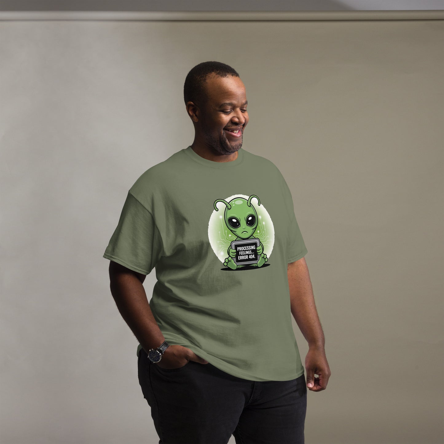 Male model wearing a military green t-shirt with cartoon alien character and humorous text.