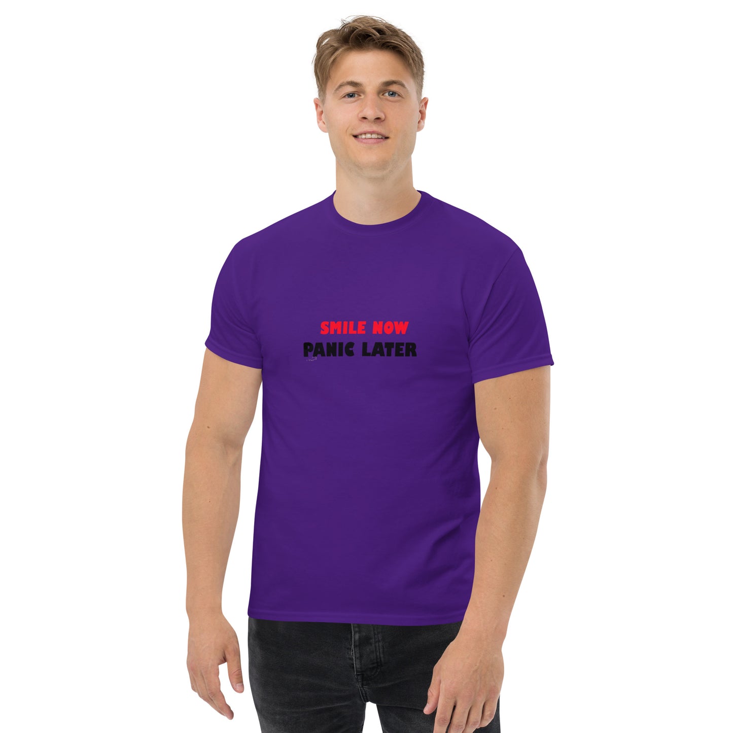 Purple unisex T-shirt with bold red 'Smile Now Panic Later' text on the front. Casual and expressive fashion