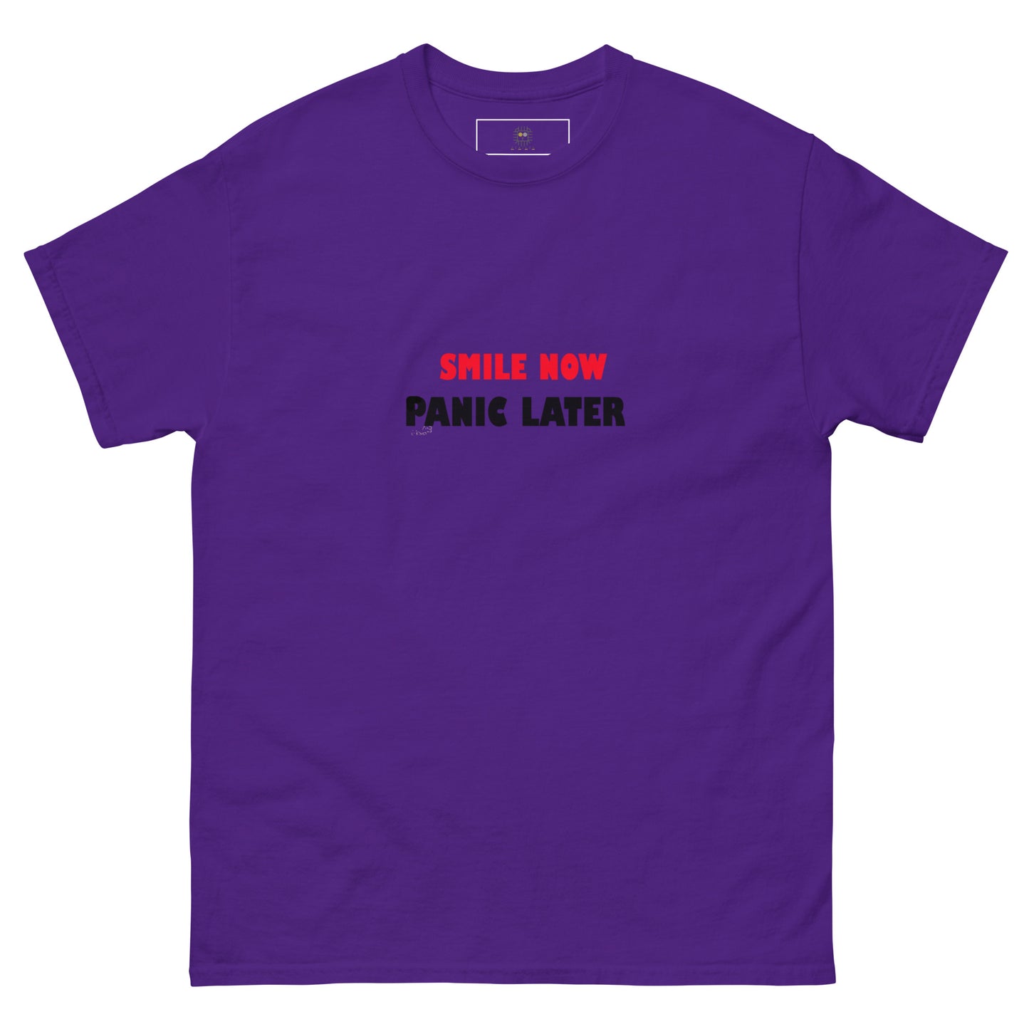 Purple unisex T-shirt with bold red 'Smile Now Panic Later' text on the front. Minimalist statement style