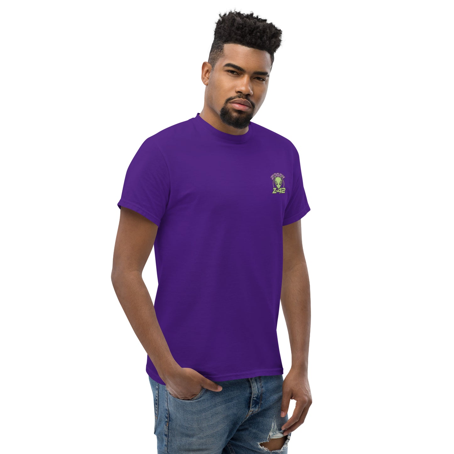 Male model wearing purple T-shirt — back print: green alien with text OFFICIALLY TOO ALIEN FOR YOU HUMANS