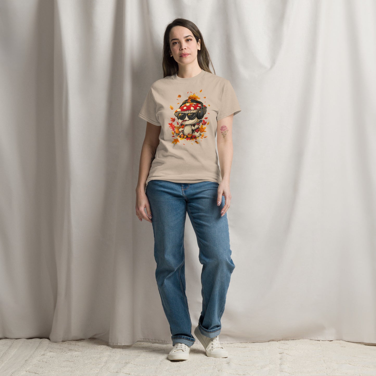 Female model in a beige t-shirt with mushroom character and leaves print.