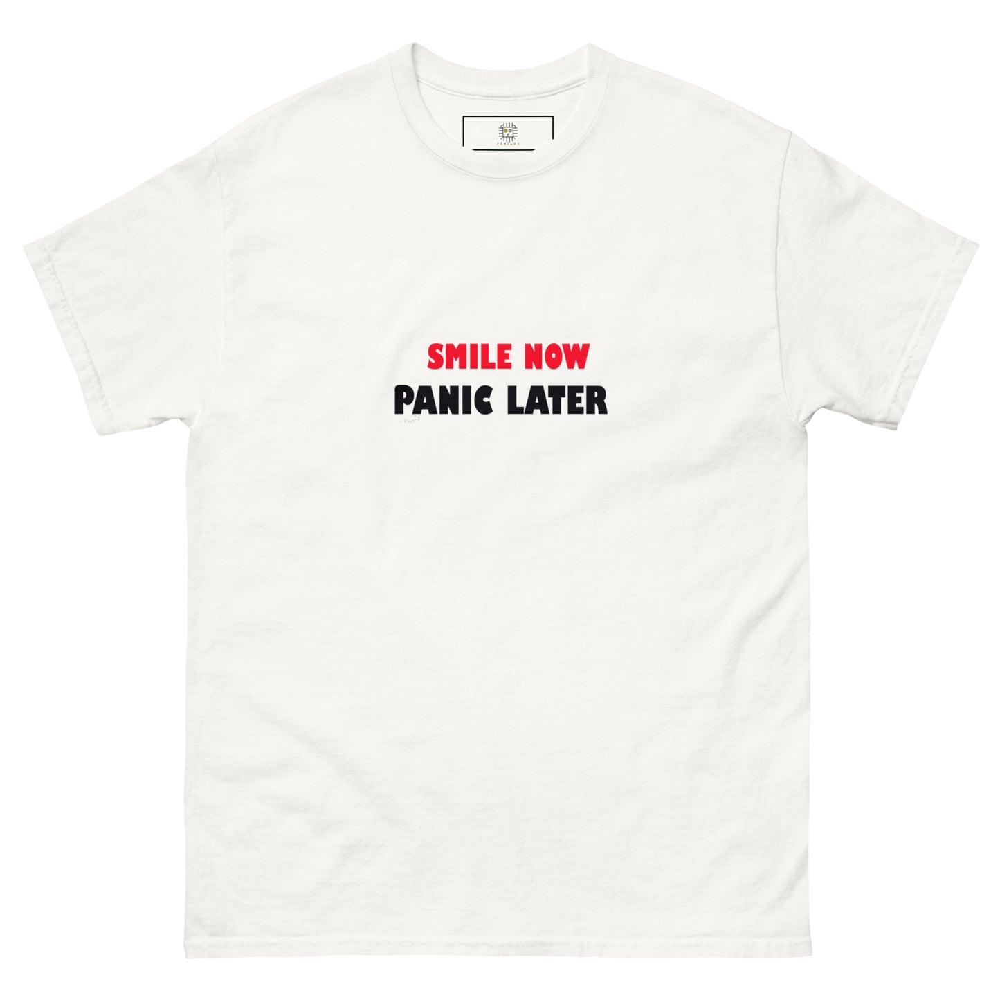 White unisex T-shirt with 'Smile Now Panic Later' in red on the front. Simple yet impactful streetwear