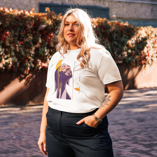 Female model wearing white T-shirt outdoors — front print: Bob Marley portrait in purple and yellow with text “Be Happy”.