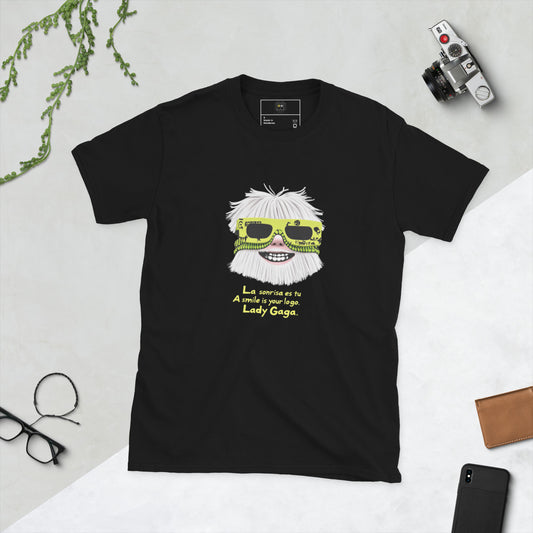 Black unisex T-shirt – front print: stylized face with white hair and neon yellow sunglasses, text “La sonrisa es tu / A smile is your logo. – Lady Gaga.”