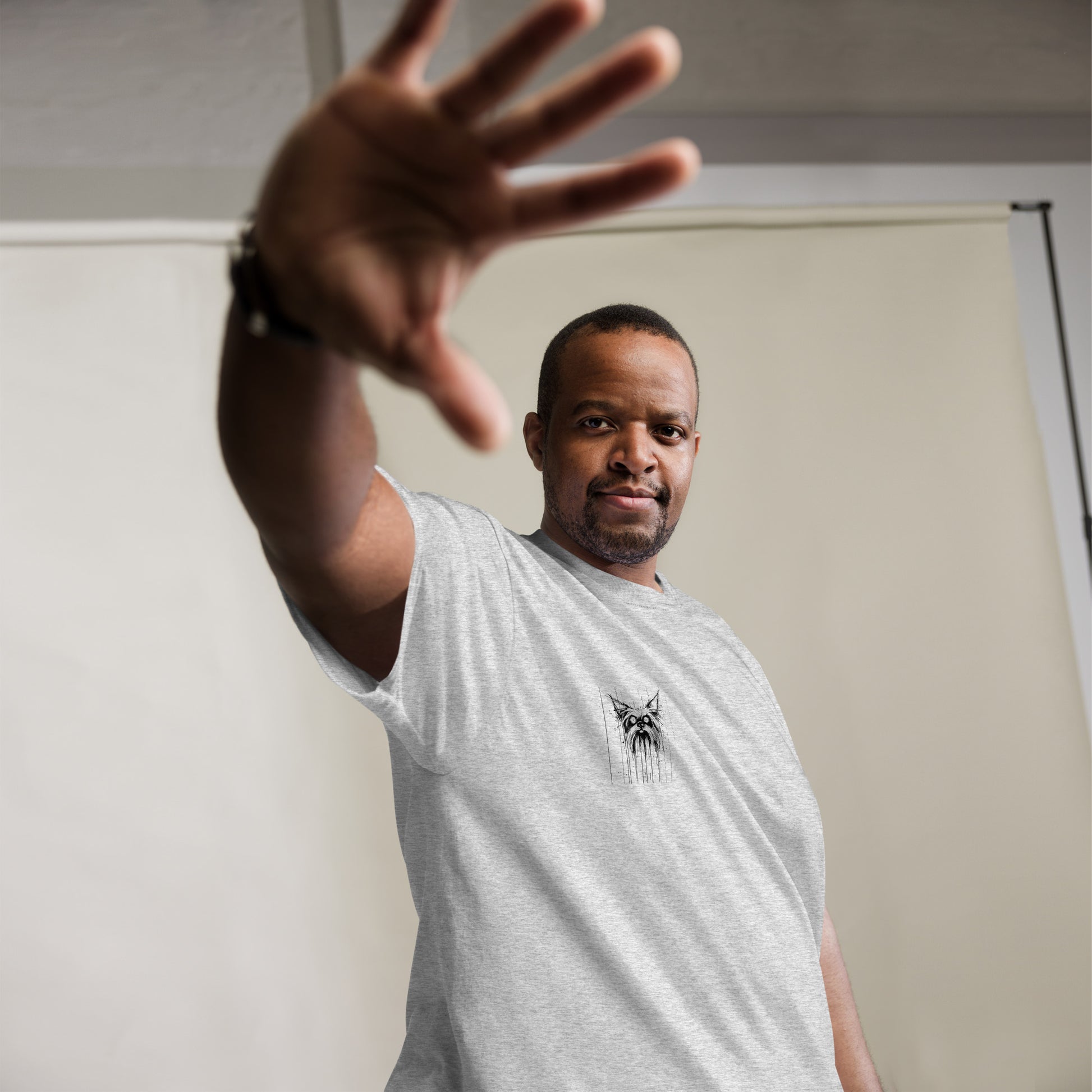 Male model raising hand playfully, wearing striped grey T-shirt with Yorkshire Terrier "Scared" artwork