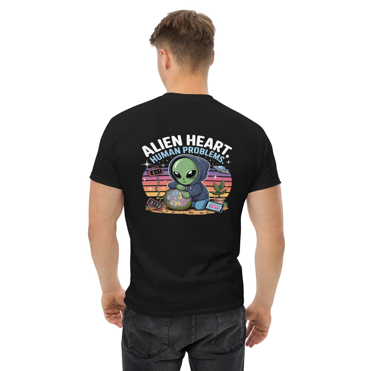 Male model wearing black T-shirt — back print: green alien in floral frame with text ALIEN HEART