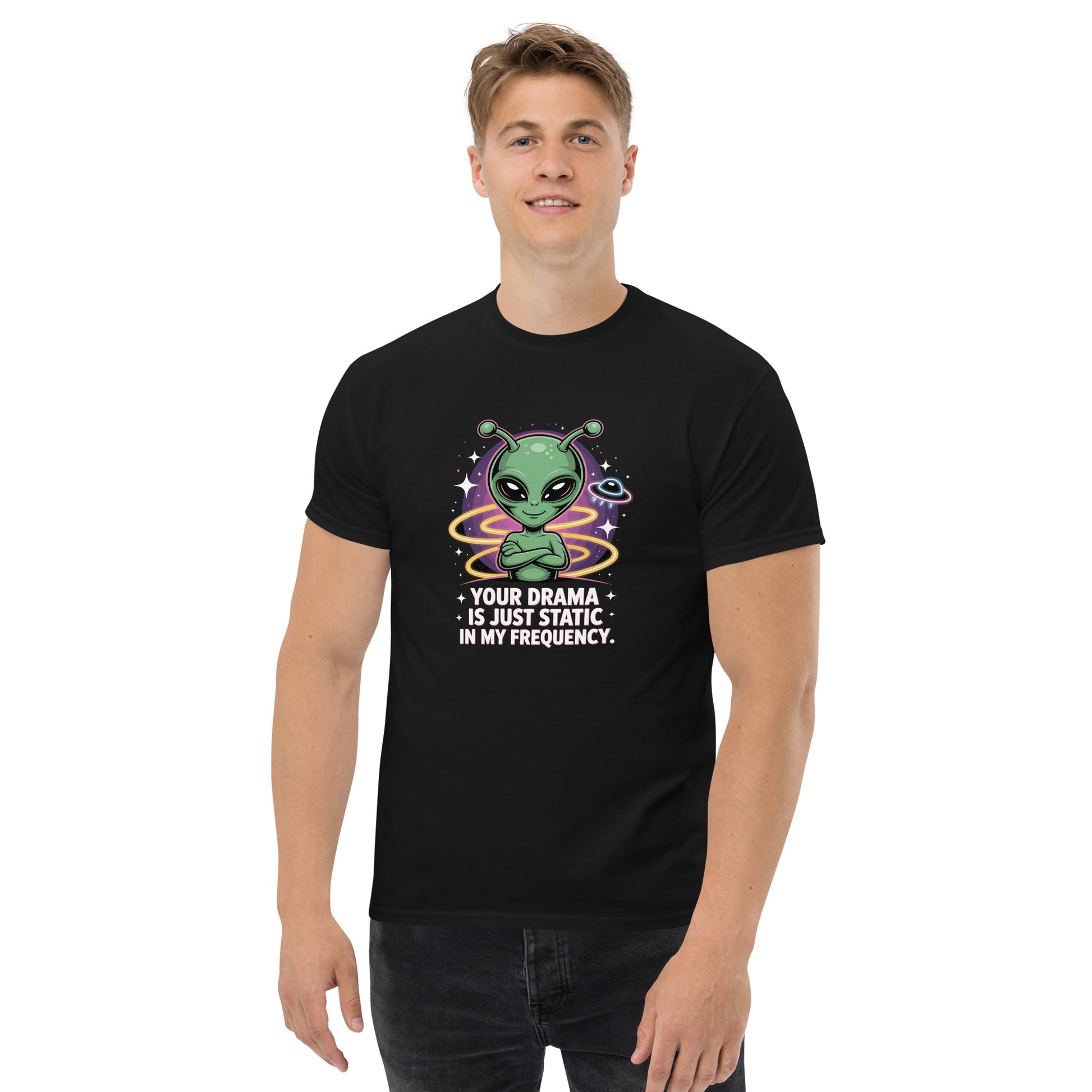 Male model wearing black T-shirt — front print: green alien with colorful background and text YOUR DRAMA IS NOT SPEAKING MY FREQUENCY