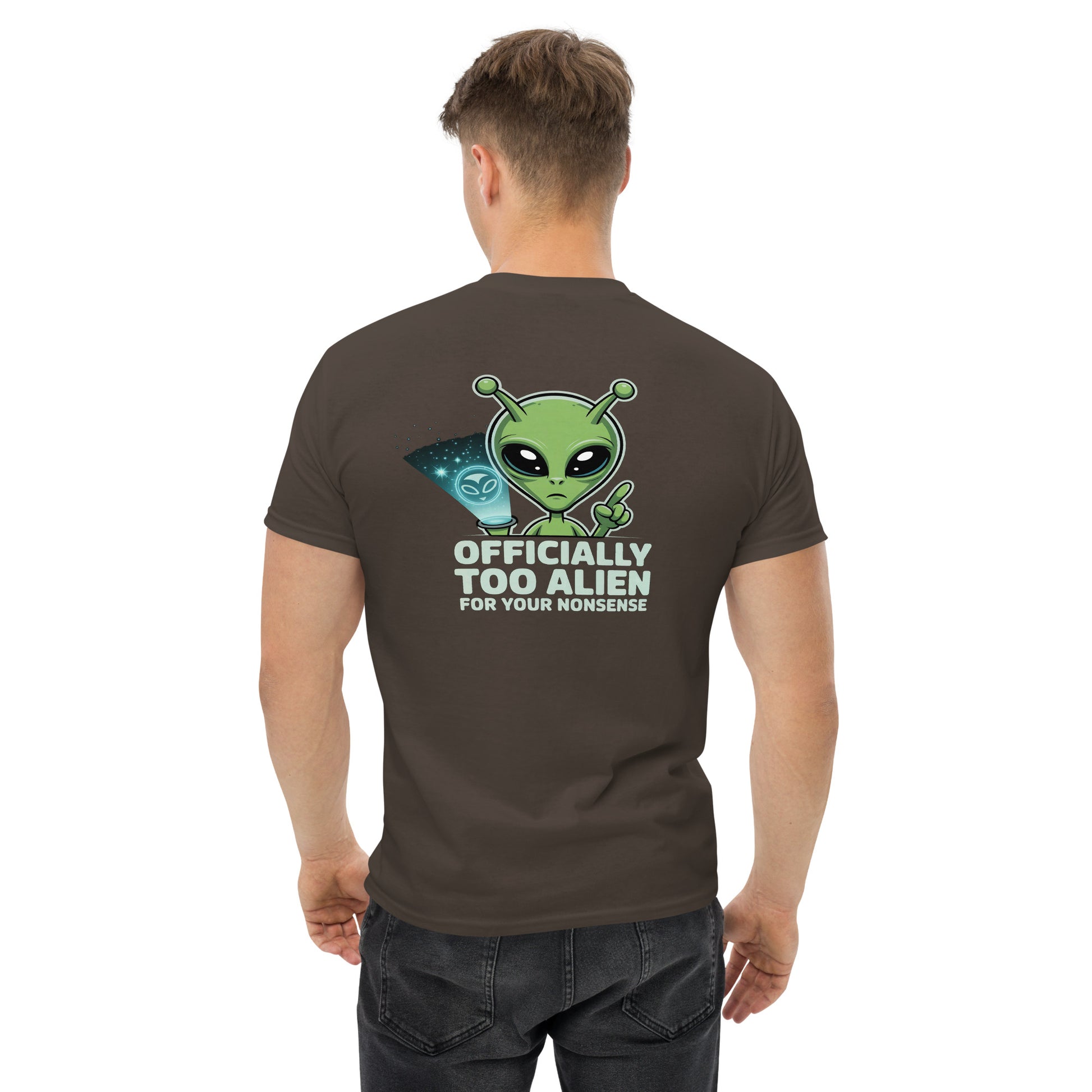 Male model wearing brown T-shirt — back print: green alien with text OFFICIALLY TOO ALIEN FOR YOU HUMANS