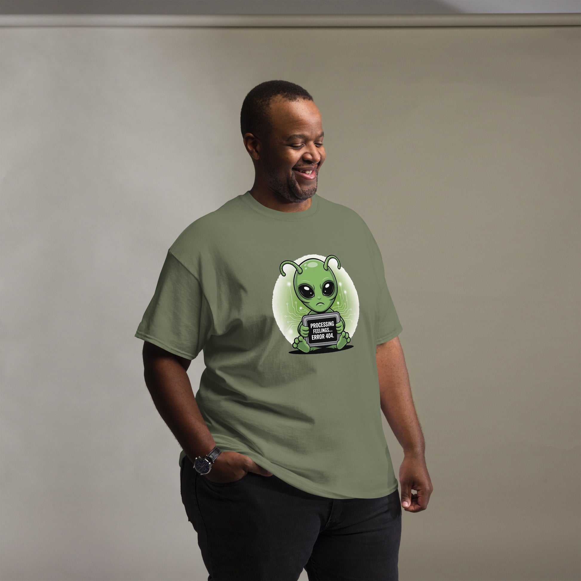 Male model wearing a military green t-shirt with cartoon alien character and humorous text.