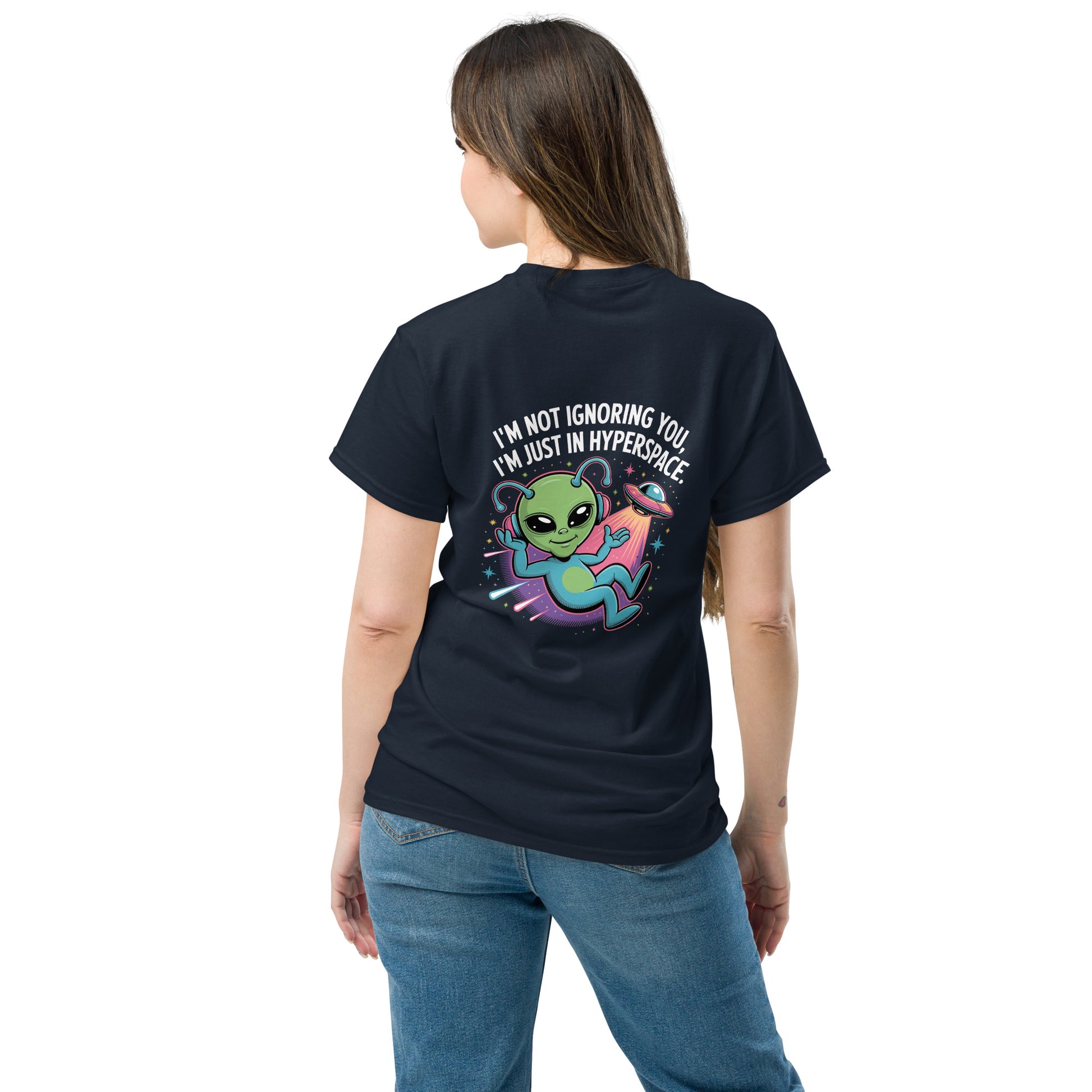 Female model wearing black T-shirt — back print: green alien in spaceship with text I’M NOT IGNORING YOU, I’M JUST IN MY SPACESHIP