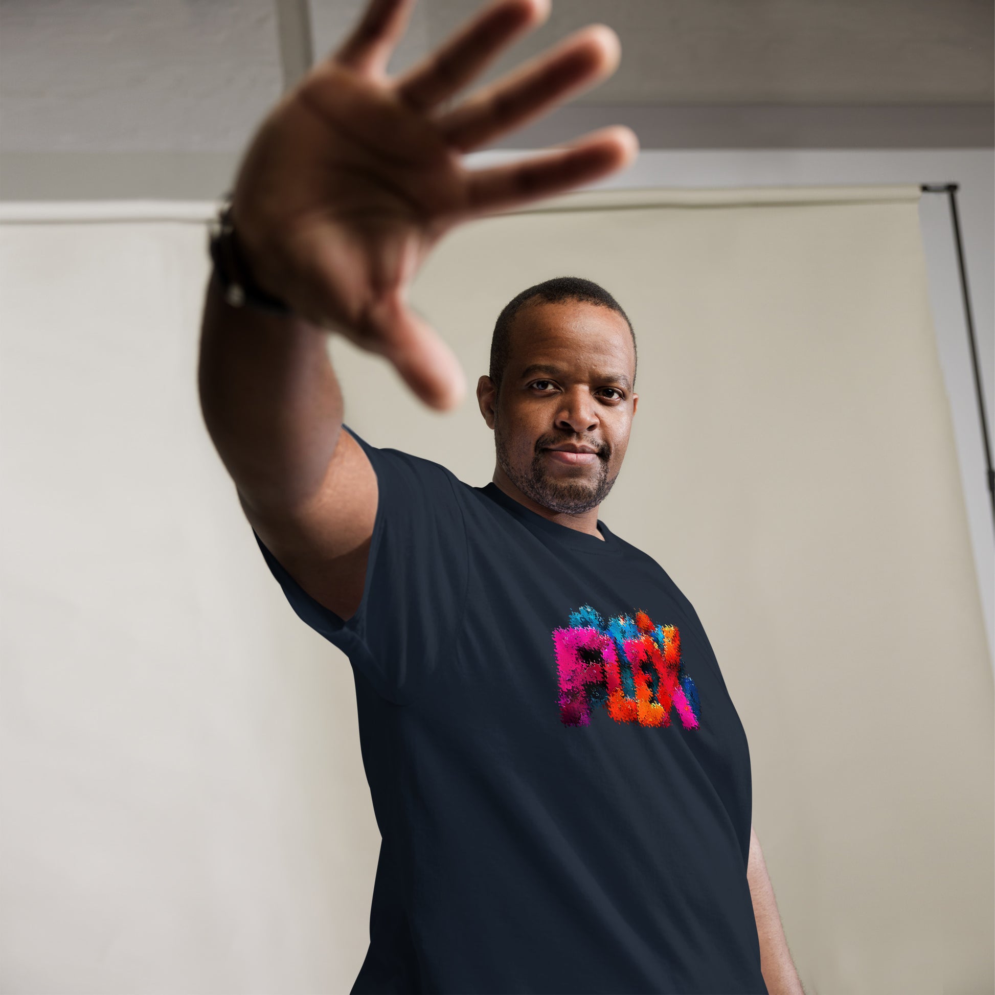 Male model: Man wearing navy FLEX glitch t-shirt with bold multicolor distorted lettering, urban streetwear look.