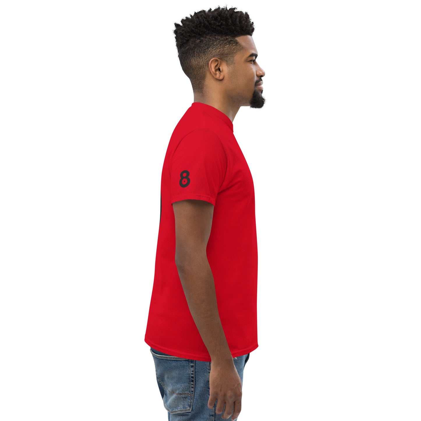 Side view of the red t-shirt highlighting the clean silhouette and fabric drape. The absence of front graphics keeps attention on the back and sleeve details.