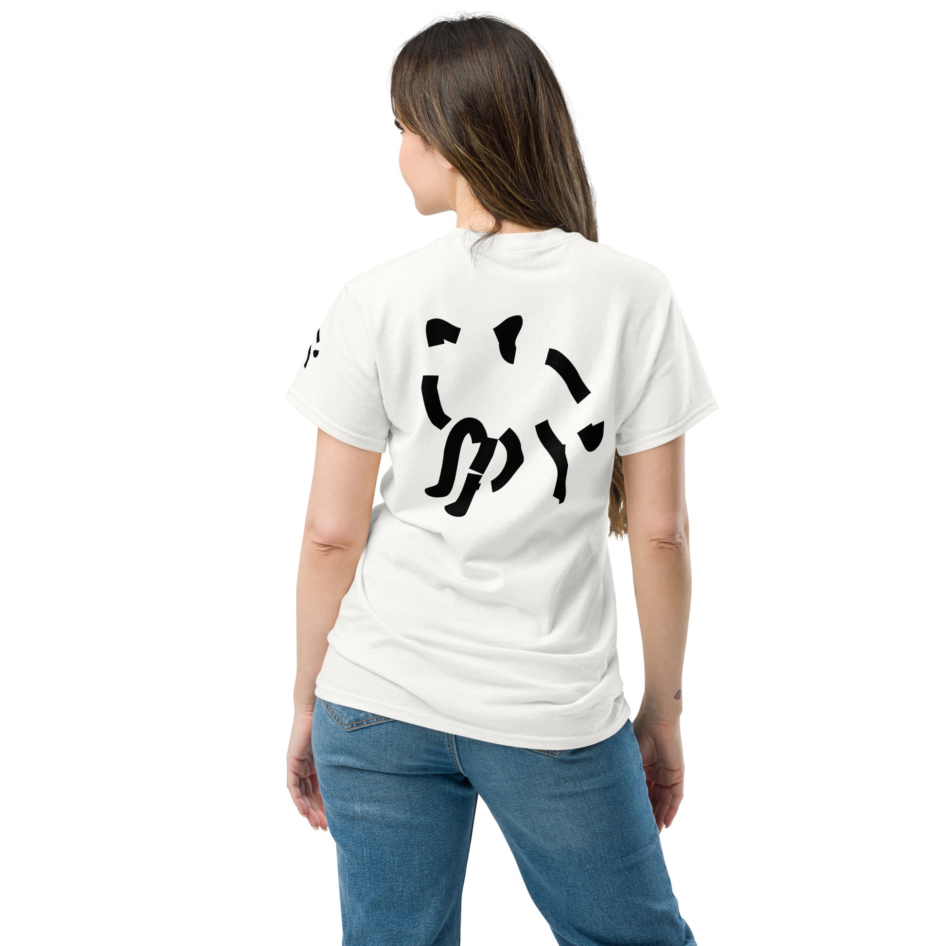 Back view of a white t-shirt worn by a female model, featuring a fragmented black graphic centered on the upper back. The broken shapes form a structured composition that stands out against the clean fabric.