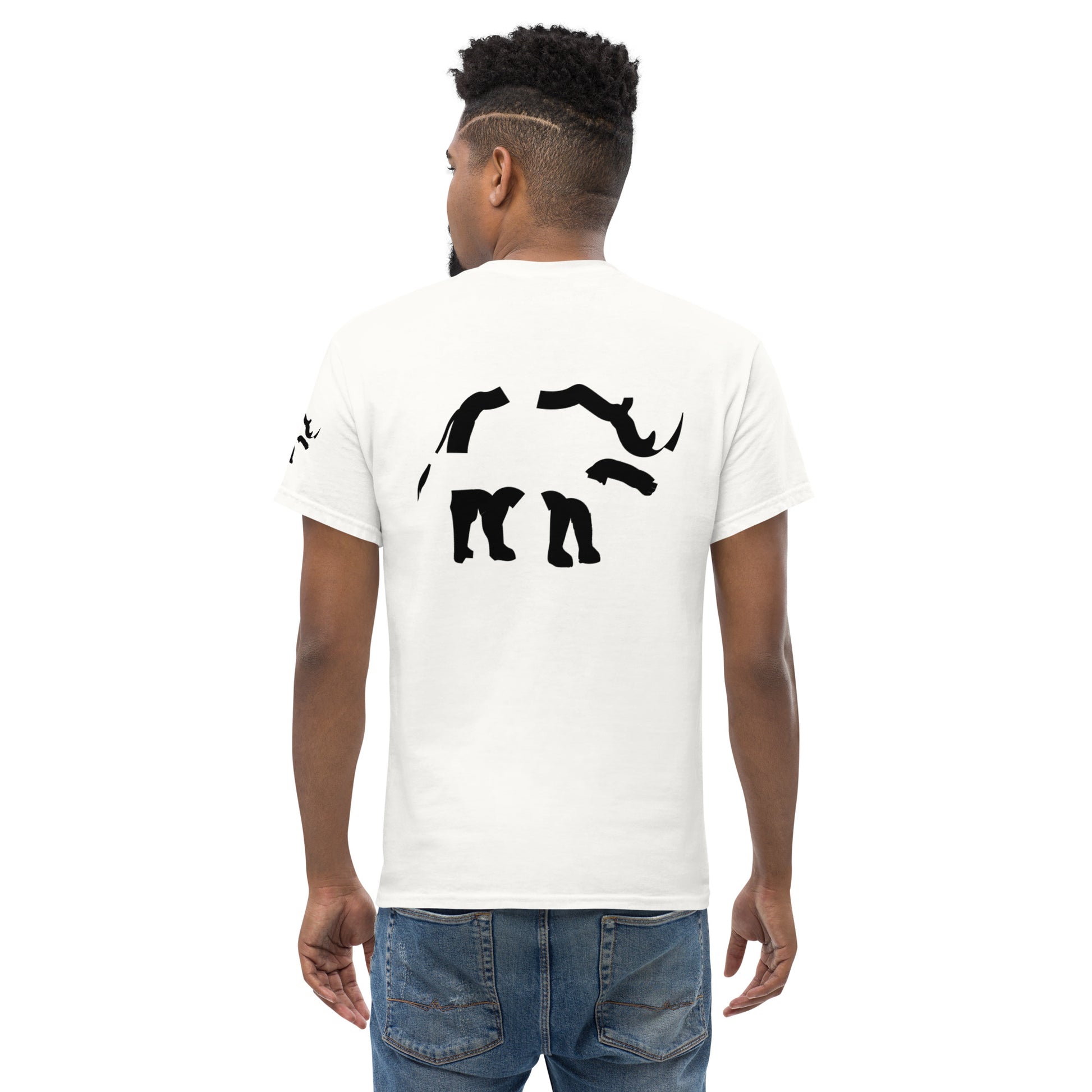 Back view of a white t-shirt worn by a male model, featuring a fragmented black graphic centered on the upper back. The composition is clearly structured, with separated shapes forming a cohesive visual rhythm.