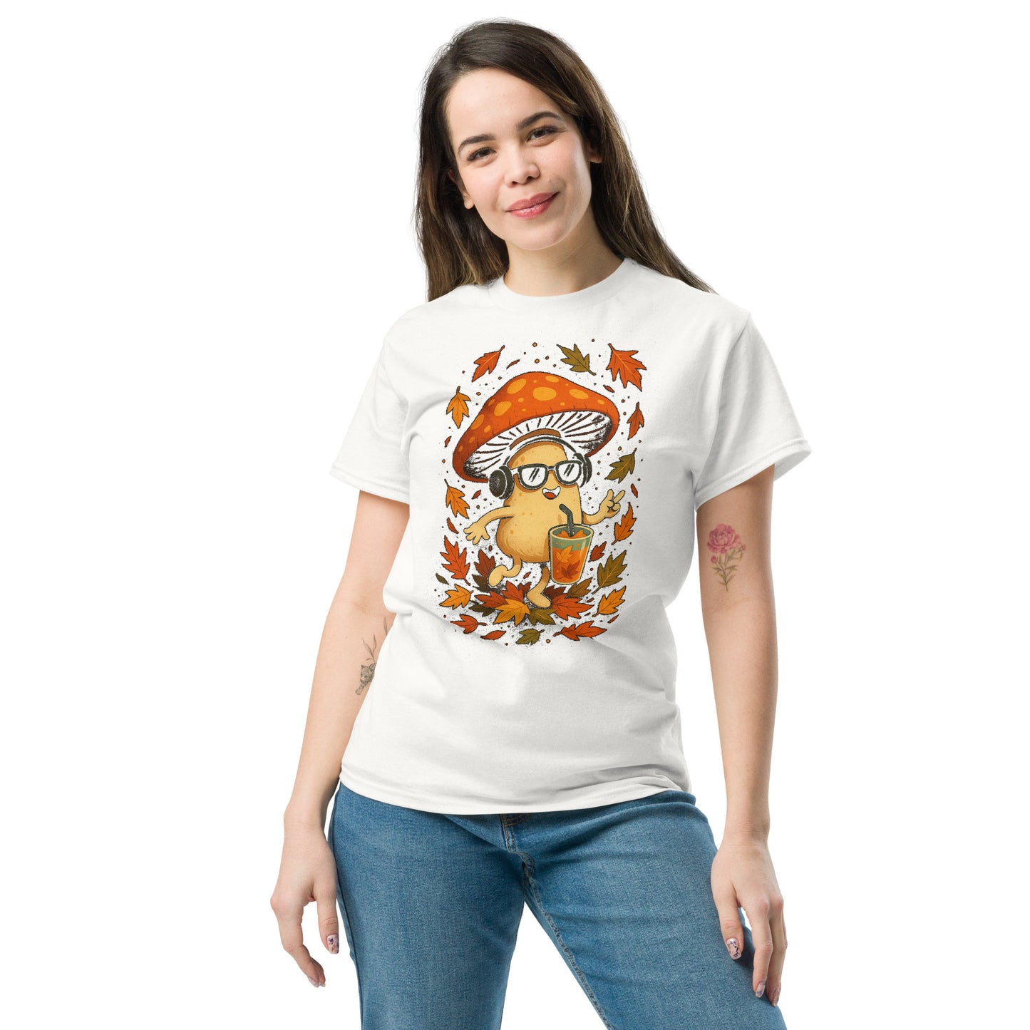 White T-shirt on female model (front view) – playful autumn mushroom with headphones and drink, surrounded by autumn leaves.