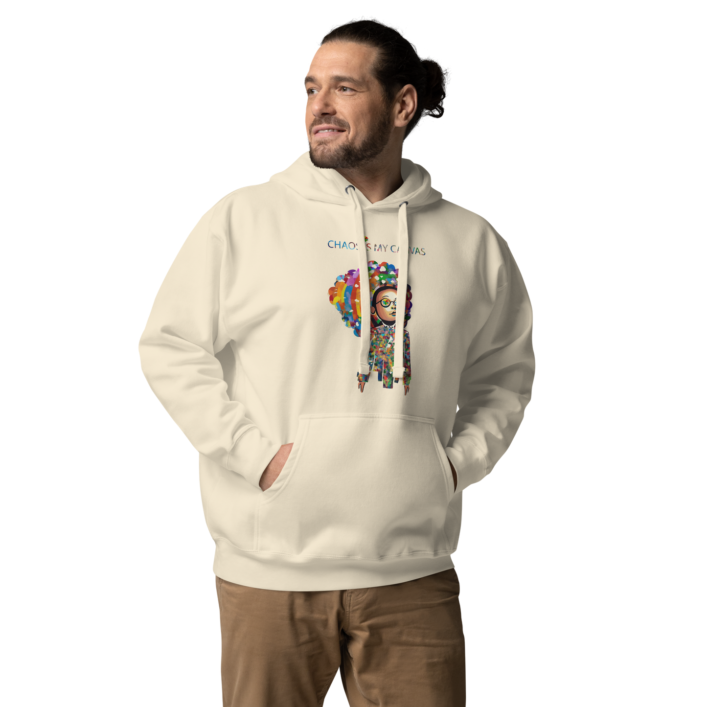 Man wearing a cream unisex hoodie featuring the Be a Rainbow graphic with colorful artistic details and an uplifting inspirational message