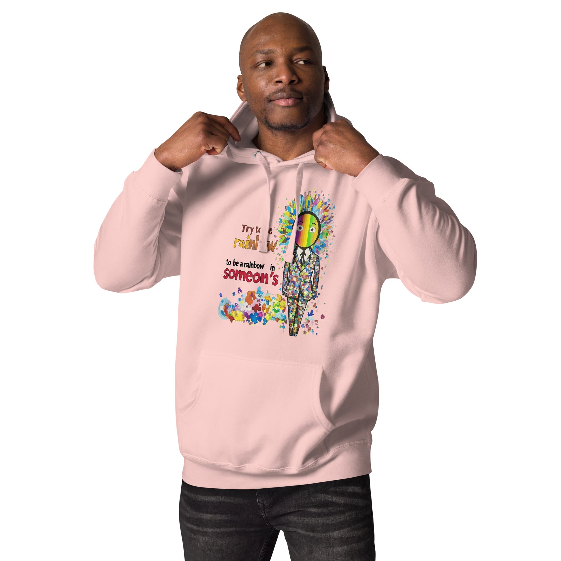 Man wearing a pink unisex hoodie featuring the Be a Rainbow illustration with colorful abstract elements, cheerful design, and positive streetwear style.