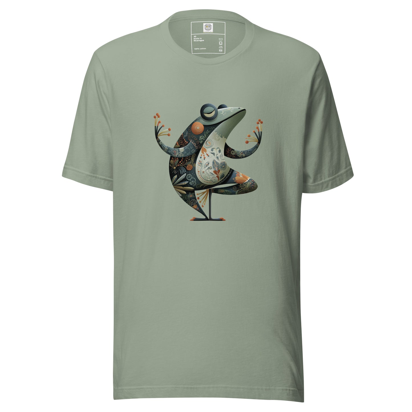 A sage green t-shirt displayed on a neutral background featuring a colorful artistic bird illustration standing in a cocktail glass. The design combines abstract shapes and decorative elements in warm and cool tones, creating a playful and stylish graphic.