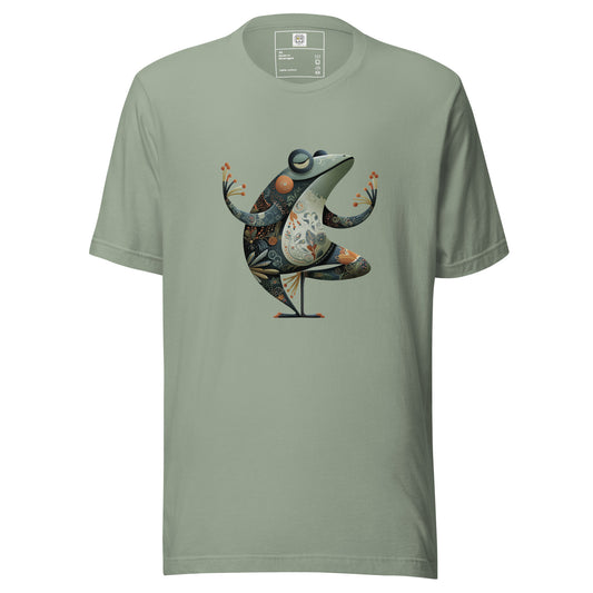 A sage green t-shirt displayed on a neutral background featuring a colorful artistic bird illustration standing in a cocktail glass. The design combines abstract shapes and decorative elements in warm and cool tones, creating a playful and stylish graphic.